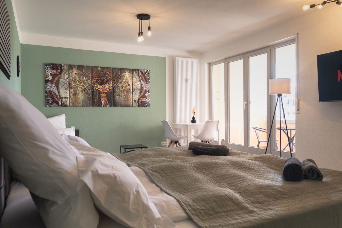 Home Shanti Ferienwohnung Leipzig - Gemütlicher Wohnbereich mit Bett, Essbereich und Netflix